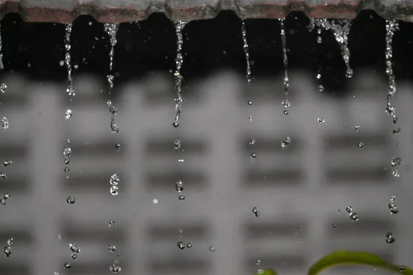 Gocce di movimento di pioggia d'acqua dal tetto, messa a fuoco morbida — Foto Stock