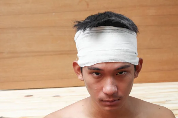 Anak muda dengan trauma di kepala. dengan perban medis — Stok Foto
