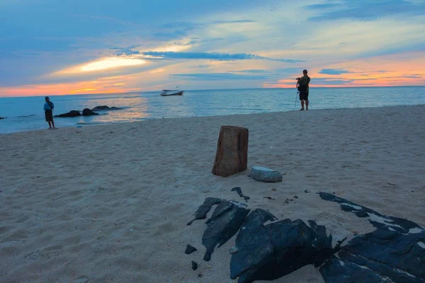 日の出の朝の時間前に、カメラマンはビーチで漁師. — ストック写真
