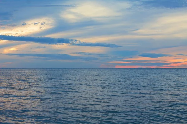 Ανατολή του ήλιου το πρωί πριν από τον πολύχρωμο ουρανό και στην θάλασσα και την παραλία με αντανακλαστικό νερό — Φωτογραφία Αρχείου