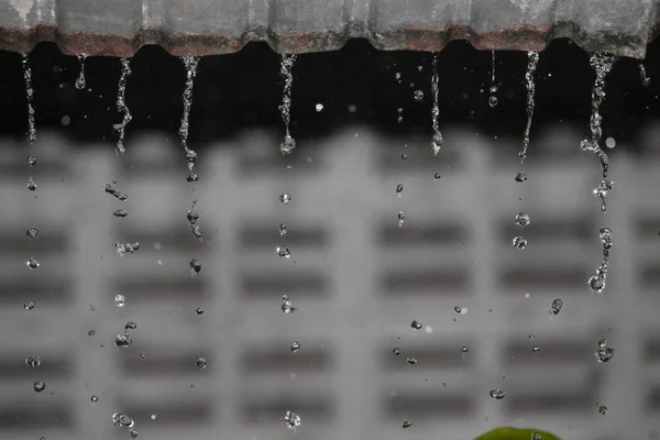 Blur blurred , Motion drop of water rain from roof at night — Stock Photo, Image