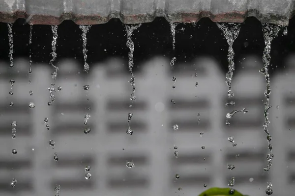 Borrão desfocado, queda de movimento de chuva de água do telhado à noite — Fotografia de Stock