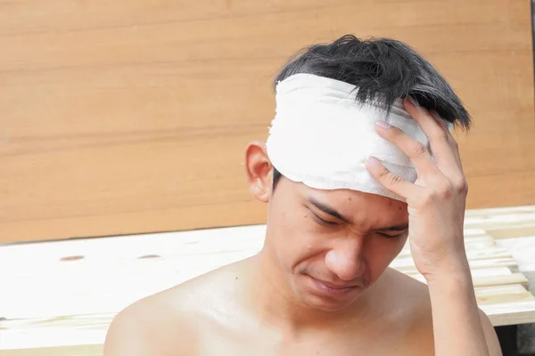 Mladý muž s poraněním hlavy. podle lékařských obvaz — Stock fotografie
