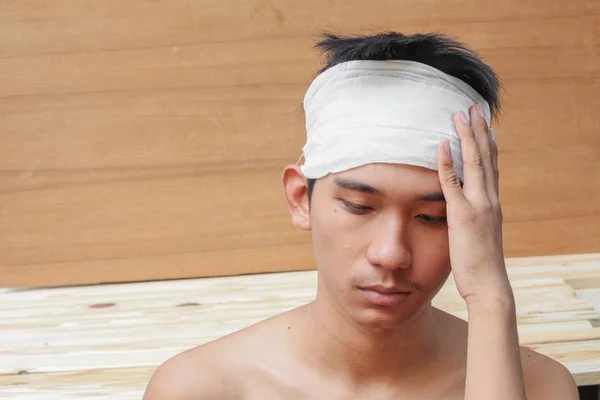 Jovem com trauma na cabeça. por atadura médica — Fotografia de Stock
