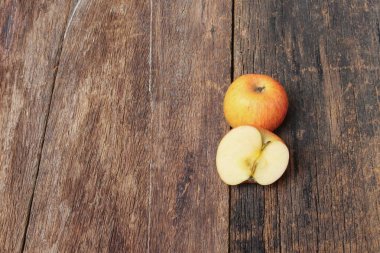 Kırmızı elma ve dilim üzerinde ahşap arka plan, üstten görünüm 