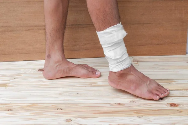 Gauze bandage of physician the treating case with ankle Injured — Stock Photo, Image