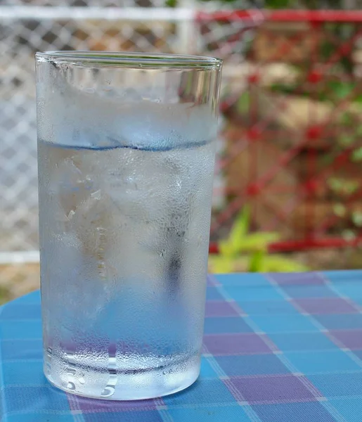 Холодная вода на деревянном столе. стакан холодного свежего напитка со льдом — стоковое фото