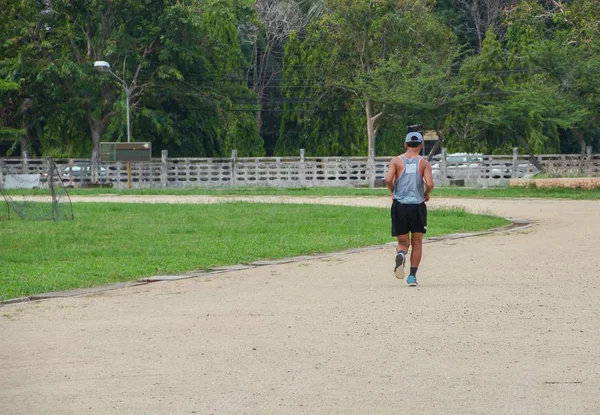 Молодой человек бегает в парке, вид сзади — стоковое фото