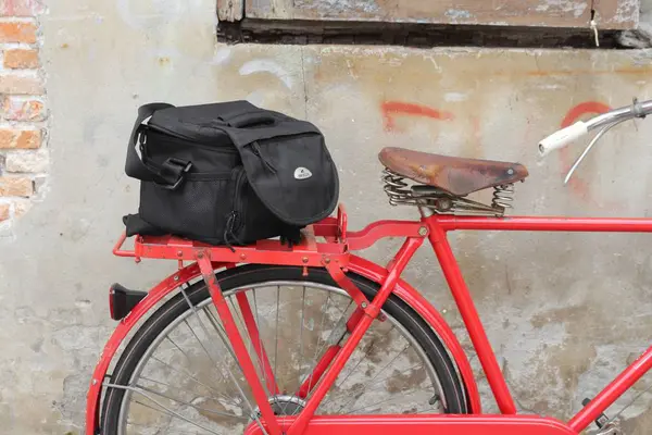Väska svart cykel resor sadeln närbild, Gammal tegel vägg bakgrund — Stockfoto