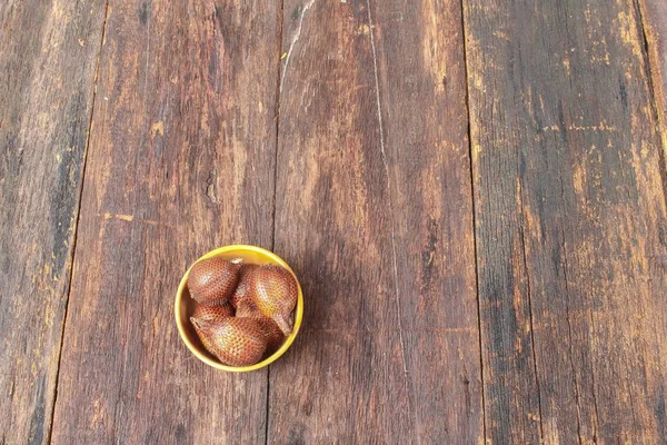 Salak φρούτα, γογγυλοκράμβες zalacca στο Κύπελλο για το ιστορικό ξύλινο πάτωμα — Φωτογραφία Αρχείου