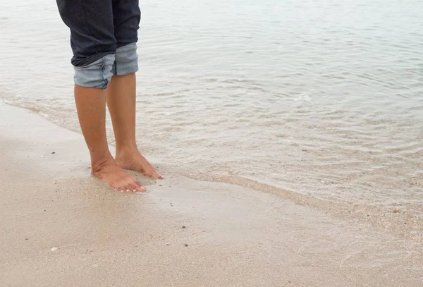 Piernas descalzas caminando en la orilla del mar, vacaciones en verano — Foto de Stock