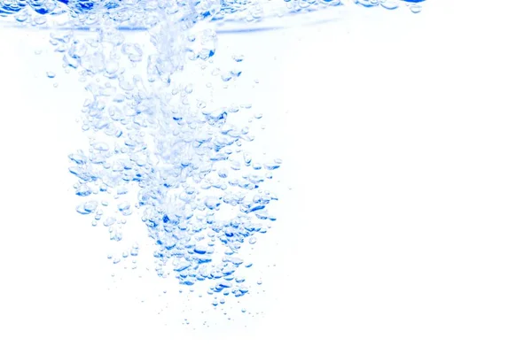 Сплеск води з бульбашками повітря, на синьому фоні . — стокове фото