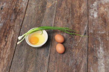 Çiğ yumurta bir kase seçici odak ve soğan ahşap tablo