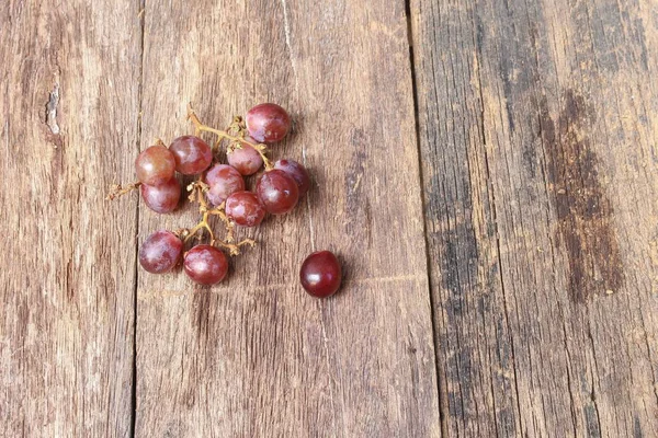 Виноград червоний свіжий на дерев'яному фоні столу, вид зверху — стокове фото