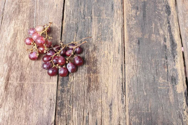 Winogrono czerwone świeże na tle drewniany stół, widok z góry — Zdjęcie stockowe