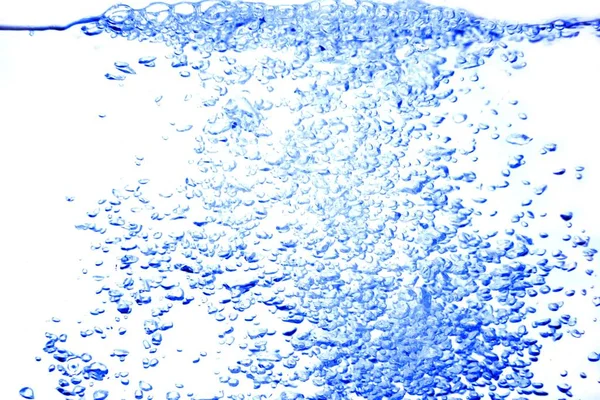 Розщеплення руху води синьою хвилею, з бульбашками повітря на білому тлі — стокове фото