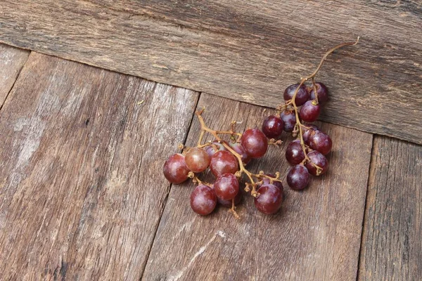 Виноград красный свежий на деревянном фоне стола — стоковое фото