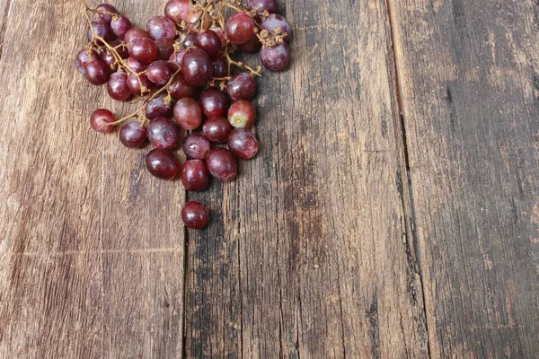 Виноград красный свежий на деревянном фоне стола — стоковое фото