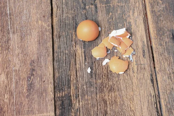 Casca do ovo espalhado no fundo da mesa de madeira — Fotografia de Stock