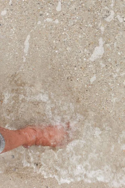 Pierna descalza caminando en la playa, vacaciones en el movimiento del mar de verano — Foto de Stock