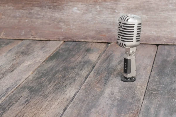 Retro microphone. Vintage style on the wooden floor background