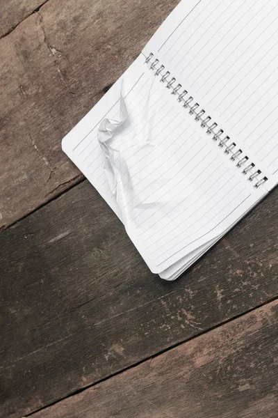 Notebook amassado em mesa de madeira, conceito de negócio — Fotografia de Stock