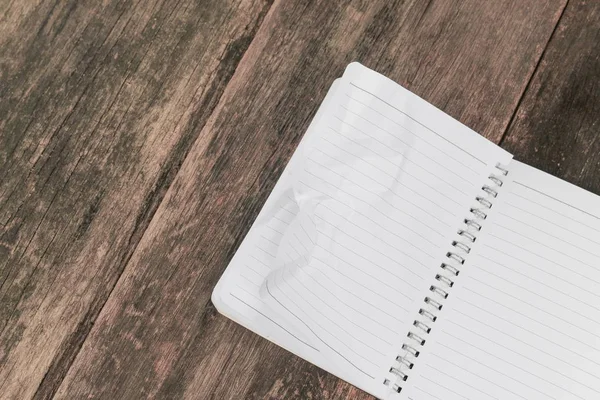 Notebook amassado em mesa de madeira, conceito de negócio — Fotografia de Stock