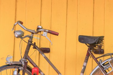 Vintage Bisiklet eski stil sarı duvar ahşap arka plan üzerinde paslı.