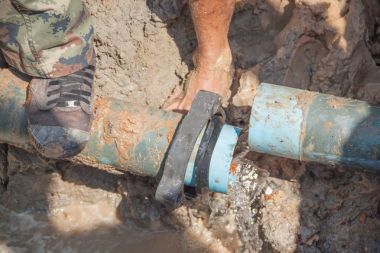 İşçiler bacak stomp üzerinde delik fix su kaçak için büyük yolda kırık sıhhi tesisat tamir