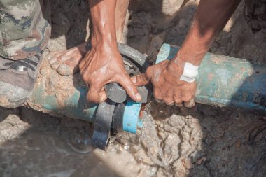 İşçiler bacak stomp üzerinde delik fix su kaçak için büyük yolda kırık sıhhi tesisat tamir