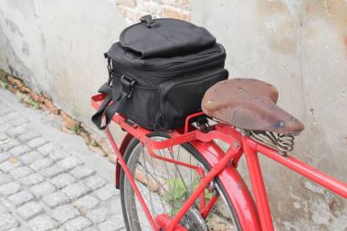 Siyah Bisiklet kırmızı seyahat eyer eski tuğla duvar arka çanta