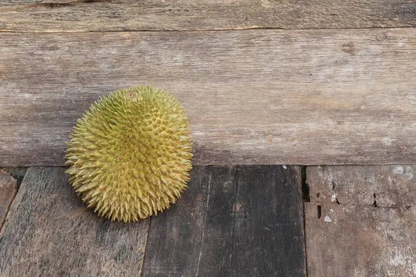 Durian fruta madura que tem espinho no fundo da placa de madeira . — Fotografia de Stock