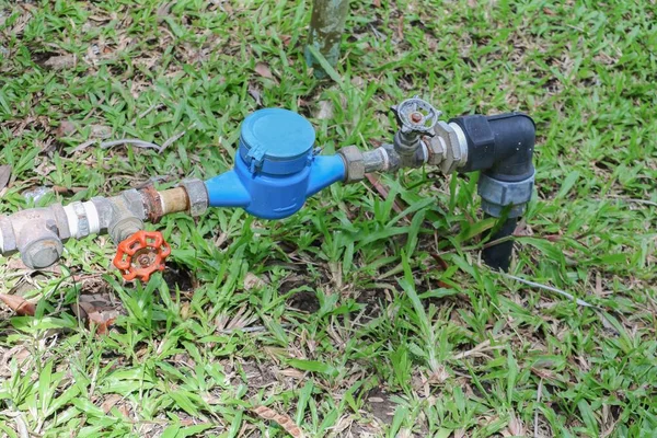 Válvula de agua y tubería de grifo en la hierba del suelo, con espacio para copias —  Fotos de Stock