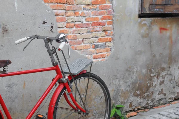 Vintage bicicleta roja cerca de la vieja pared fondo de la casa . — Foto de Stock