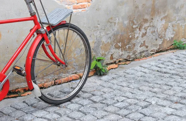 Bicicleta vermelha vintage perto da parede velha casa fundo — Fotografia de Stock