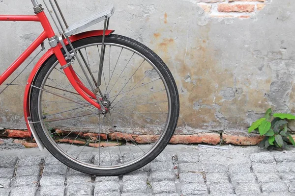 Винтажный красный велосипед рядом со старым фоном стены . — стоковое фото