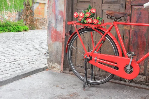 Flor en silla de montar bicicleta roja clásico vintage sobre fondo de madera de pared — Foto de Stock