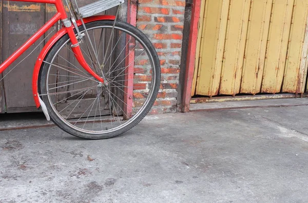 Велосипед красный классический винтаж в бывшем на фоне дерева стены — стоковое фото