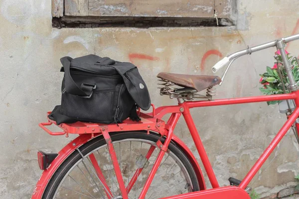 Väska svart cykel röd resor sadeln gammal tegel vägg bakgrund — Stockfoto