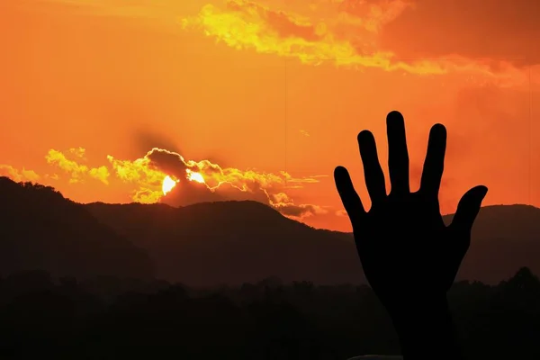 Silueta ruka s západ slunce na obloze — Stock fotografie