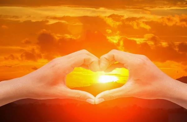 Hand forming  a heart shape with  sunset  light and copy space — Stock Photo, Image