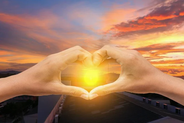 Hand forming  a heart shape with  sunset  light and copy space — Stock Photo, Image
