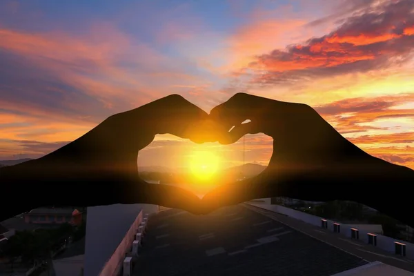 Hand forming silhouette a heart shape with  sunset  light — Stock Photo, Image