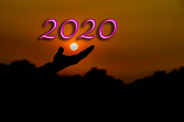 Nuevo concepto de año 2020 y silueta de manos. amanecer - fondo del atardecer — Foto de Stock