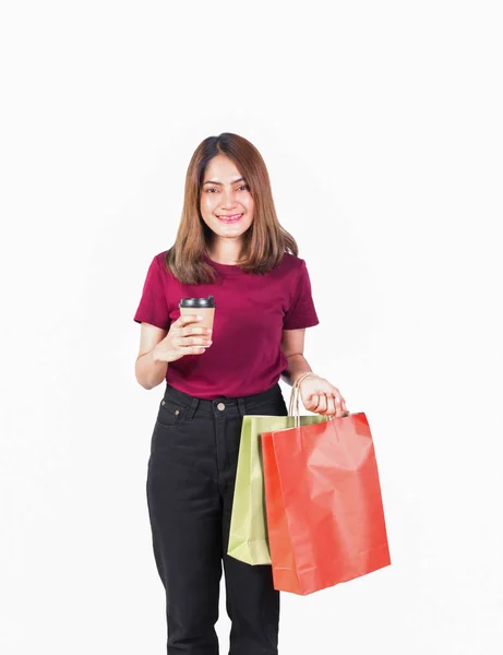 女人在购物时拿着纸袋和咖啡杯笑得很开心。 在白色背景上看相机在白色背景上 — 图库照片