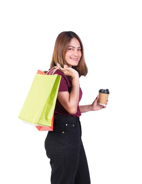 女人在购物时拿着纸袋和咖啡杯笑得很开心。 在白色背景上看相机在白色背景上 — 图库照片