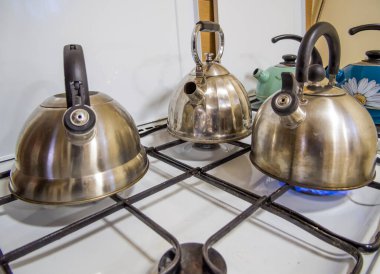 Birkaç çaydanlık ortak bir mutfağın gaz ocağında duruyor.