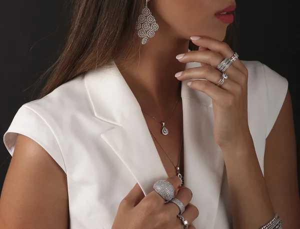 Zilveren sieraden aan de kant van de vrouw op een zwarte achtergrond — Stockfoto