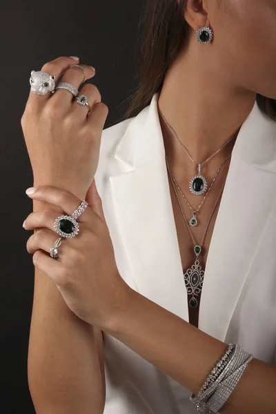 Joyería de plata sobre mano de mujer sobre fondo negro — Foto de Stock
