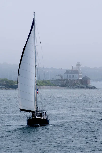 Saliboat passerar av Rose Island fyr i dimman — Stockfoto